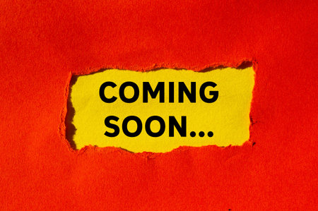 Coming soon message written on ripped torn red paper on yellow background. Conceptual coming soon...