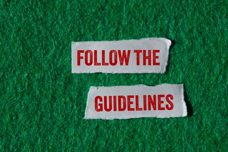 Follow the guidelines message written on torn torn paper pieces on green background. Conceptual follow the guidelines symbol. Copy space.の写真素材