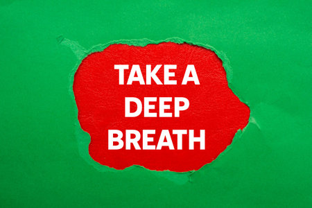 Take a deep breath message written on ripped torn green paper on red background. Conceptual take a deep breath symbol. Copy space.の写真素材
