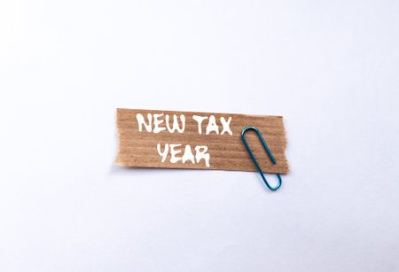 New tax year message written on ripped torn brown paper piece on white background. Conceptual new tax year symbol. Copy space.の写真素材
