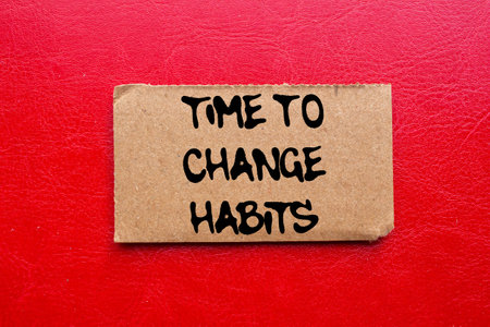 Time to change habits message written on torn torn cardboard paper piece on red background. Conceptual time to change habits symbol. Copy space.の写真素材