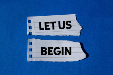 Let us begin message written on torn torn white paper pieces on blue background. Conceptual let us begin symbol. Copy space.の写真素材