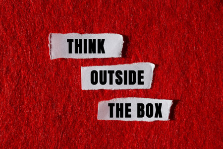 Think outside the box message written on torn torn white paper pieces on red background. Conceptual think outside the box symbol. Copy space.の写真素材