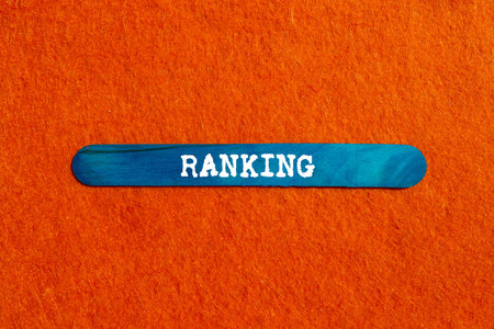 Ranking message written on blue wooden stick on orange background. Conceptual ranking symbol. Copy space.の写真素材