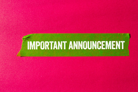 Important announcement message written on ripped torn green paper tape on pink background. Conceptual important announcement symbol. Copy space.の写真素材