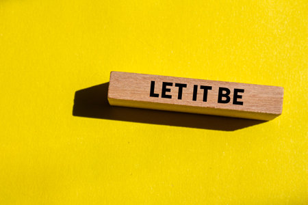 Let it be message written on wooden block on yellow background. Conceptual let it be symbol. Copy space.の写真素材