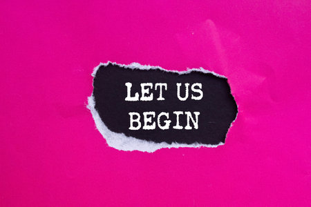 Let us begin message written on ripped torn pink paper on black background. Conceptual let us begin symbol. Copy space.の写真素材
