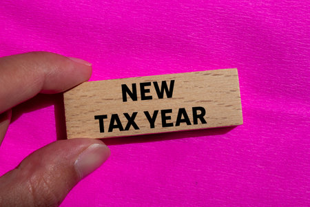 New tax year message written on wooden block on pink background. Conceptual new tax year symbol. Copy space.の写真素材