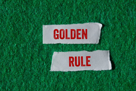 Golden rule message written on torn torn paper pieces on green background. Conceptual golden rule symbol. Copy space.の写真素材