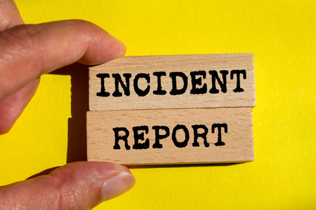 Incident report message written on wooden blocks on yellow background. Conceptual incident report symbol. Copy space.の写真素材