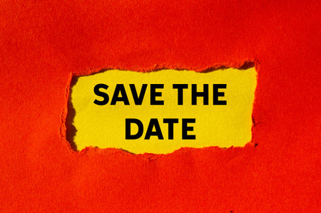 Save the date message written on ripped torn red paper on yellow background. Conceptual save the date symbol. Copy space.の写真素材