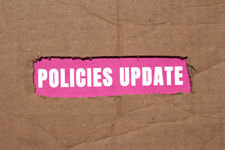 Policies update message written on torn torn cardboard paper on pink background. Conceptual policies update symbol. Copy space.の写真素材