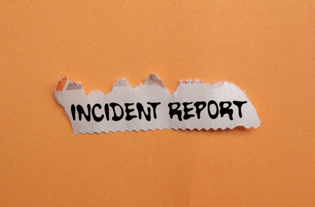 Incident report message written on ripped torn newspaper piece on orange background. Conceptual...
