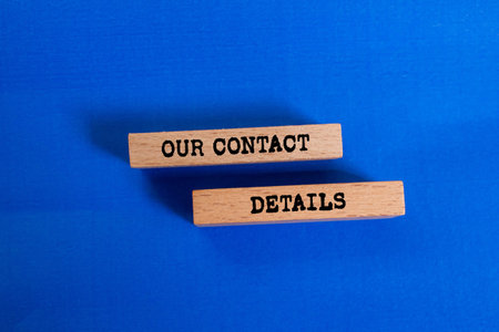 Our contact details message written on wooden blocks on blue background. Conceptual our contact...