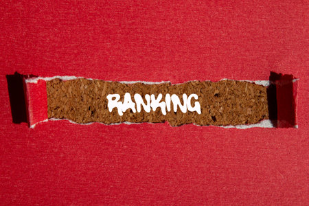 Ranking message written on ripped torn red paper on brown background. Conceptual ranking symbol. Copy space.の写真素材