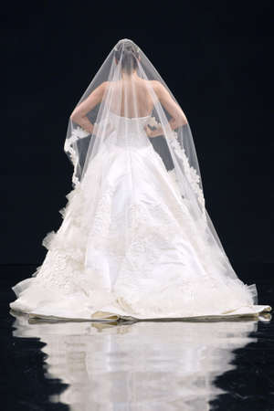 Back view of a bride with a bridal veil on a catwalk stage.の写真素材