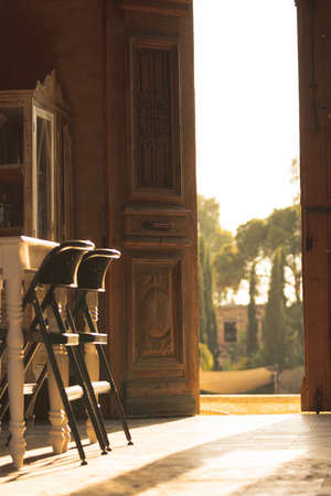 Two chairs backlit with a nice sunset at golden hour in a vintage designed cafeの写真素材