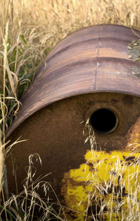 An abandoned rusted barrel in a field.の写真素材