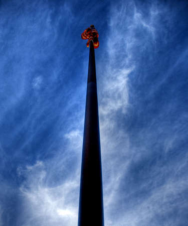 Looking up at the american flag against a brilliant blue sky with scattered puffs of clouds.の写真素材