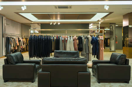 Inetior of leather and fur shop with sitting group in front and with coats and trenches in the...