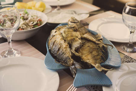 Homemade fried fish served on the dinner table. Homemade fish with other food ready to be served.