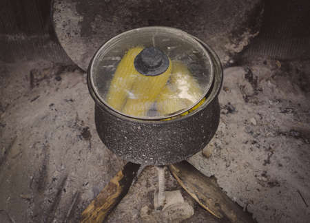 Boiled corns in the authentic pot. Authentic fireplace in the village.