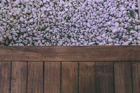 Wooden floor from above with small white stones on the other half.の写真素材