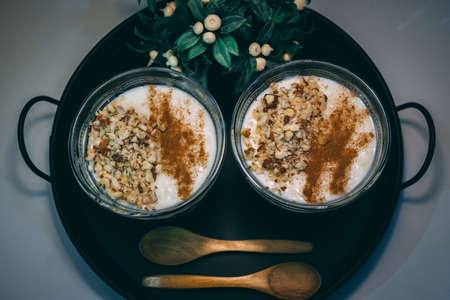 Rice pudding served in glass cups. Decorated. Close-up.Homemade dessert decorated with flower on black tray.の写真素材