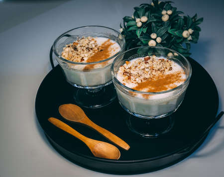 Rice pudding served in glass cups. Decorated. Close-up.Homemade dessert decorated with flower on black tray.の写真素材