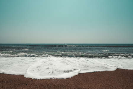 Wavy Mediterranean sea with horizon and sky. Orange tones. With positive space above. Lara Beach in Anatlya Turkey.の写真素材