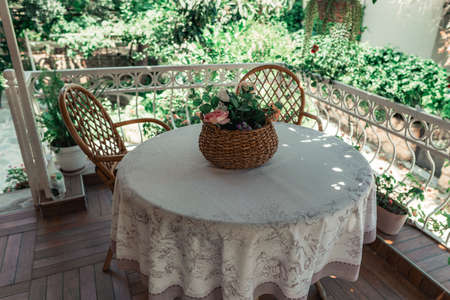 Basket with artificial flowers on vernada.の写真素材