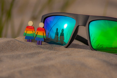 Sunglasses on the beach with reflection of a man and a womanの写真素材