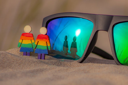 Rainbow gay couple in sunglasses on sand. LGBT concept. Selective focus.