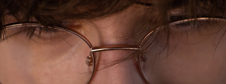 Close-up of glasses on the eyes of a young man.の写真素材