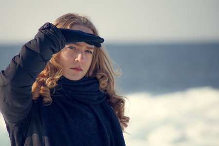 Portrait of a beautiful girl on the seashore in winterの写真素材