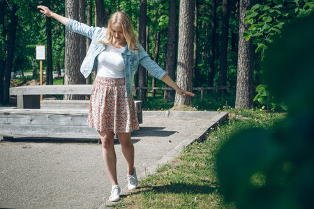 Beautiful blonde girl in a summer park. The girl is walking in the park.の写真素材