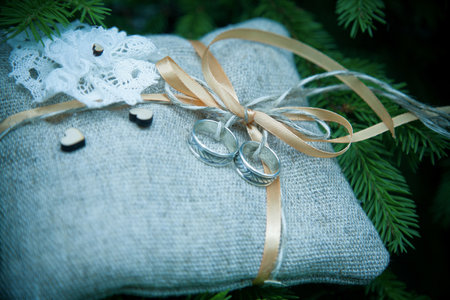 Wedding rings on a pillow against the background of the Christmas treeの写真素材