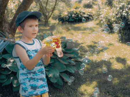 little boy blowing soap bubbles in the park. childhood and leisure conceptの写真素材