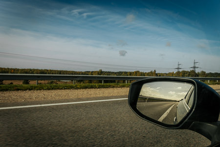 View on the road in the countryside from the car side mirror.の写真素材