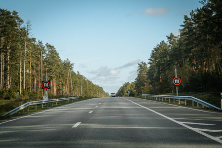 Asphalt road through the forest in the evening. Landscape.の写真素材