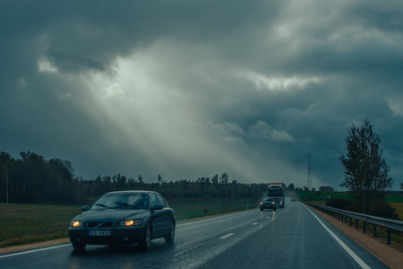 Cars driving on the road in the stormy weather with clouds.