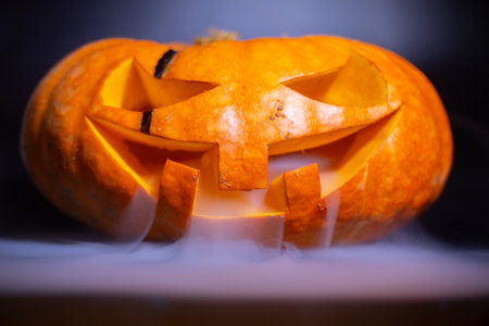 Halloween pumpkin head with smoke on dark background. Selective focusの写真素材