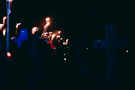 Silhouettes of people at the cross in the cemetery during a religious processionの写真素材