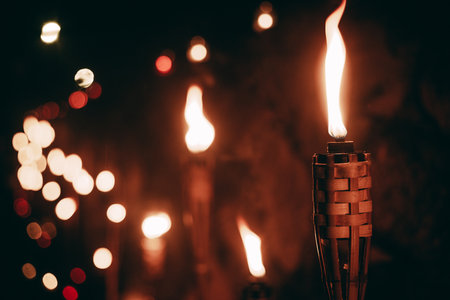 Torch of a burning candle on a dark background with bokehの写真素材