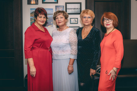 Group of senior women in red dresses standing in a row at homeの写真素材