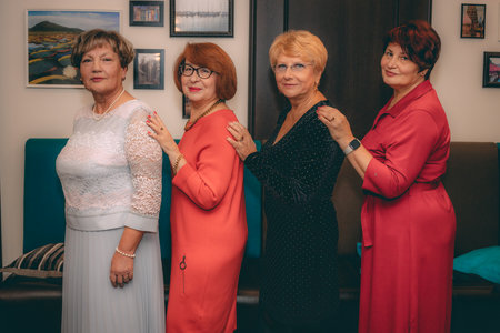 Elderly women in a red dress in a photo studio.の写真素材