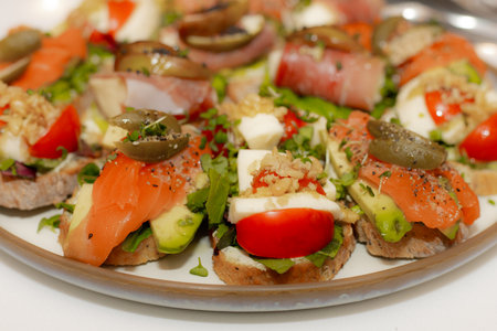 Canape with salmon, tomatoes and mozzarella on a plateの写真素材