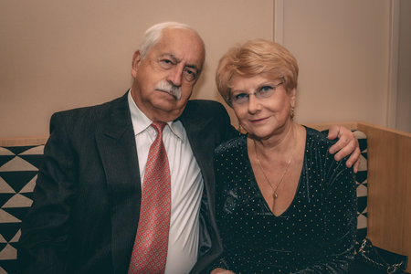 Portrait of a senior couple sitting together on a sofa at homeの写真素材