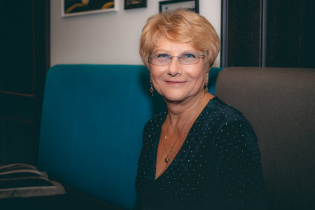 Portrait of a smiling senior woman sitting on a sofa at homeの写真素材