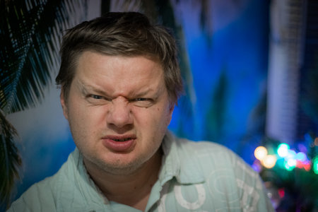 Portrait of a man in a green shirt on the background of a palm tree